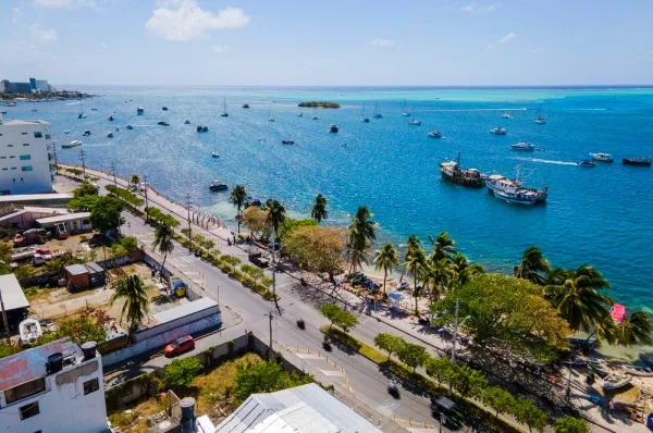 Die bebaute Küste San Andrés. Auf dem Meer schwimmen kleine Boote und Schiffe.