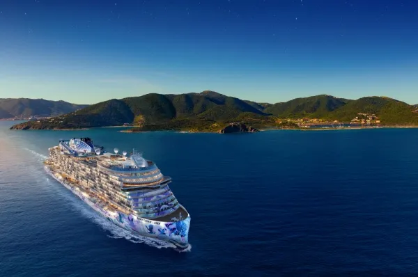 Norwegian Luna in See Die Norwegian Luna auf See mit einer Bergkette im Hintergrund