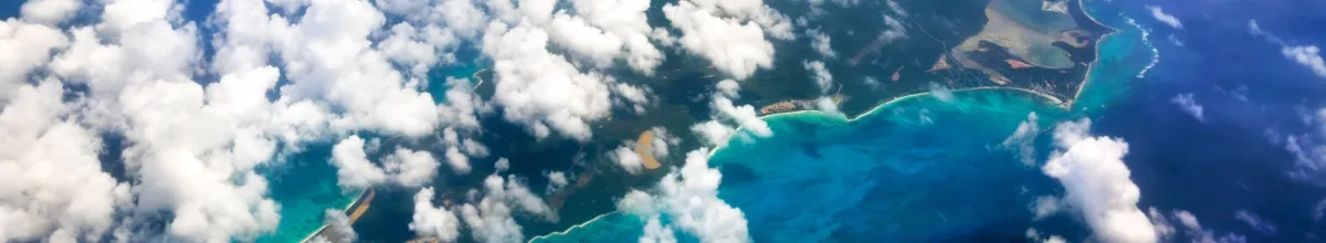 Eine Insel der Bahamas von oben durch die Wolken fotografiert.
