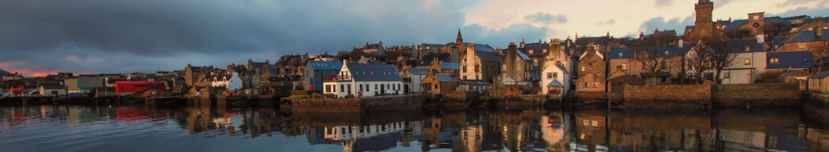 Küste von Stromness mit von der Sonne beschienenen Häusern.