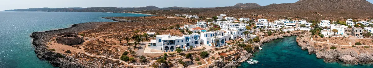 Die Stadt angeschmiegt zwischen Felsen und Meer am Tag.