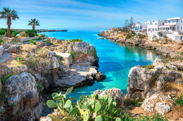 Eine Bucht bei Kythira mit heimischen Pflanzen, kristallklarem Wasser und einem Teil der Stadt rechts.
