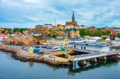 Die Stadt Lysekil vom Hafen aus fotografiert mit von natürlichen Felsen gesäumten Nachbarschaften am Tag.