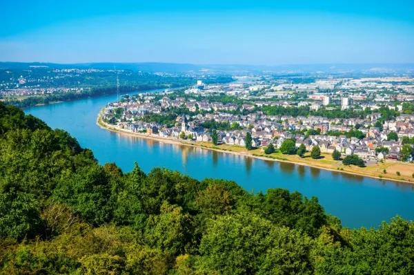 Koblenz mit einer Flusskreuzfahrt entdecken Die Stadt Koblenz vom anderen Rheinufer auf einer Erhöhung fotografiert.