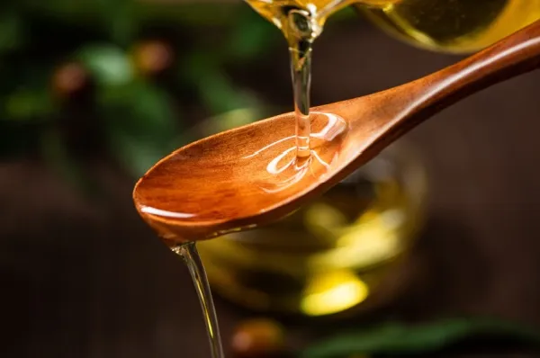 Gourmet Programm an Bord Hochwertiges Olivenöl wird für ein Tasting über einen Löffel aus Olivenholz gegossen.