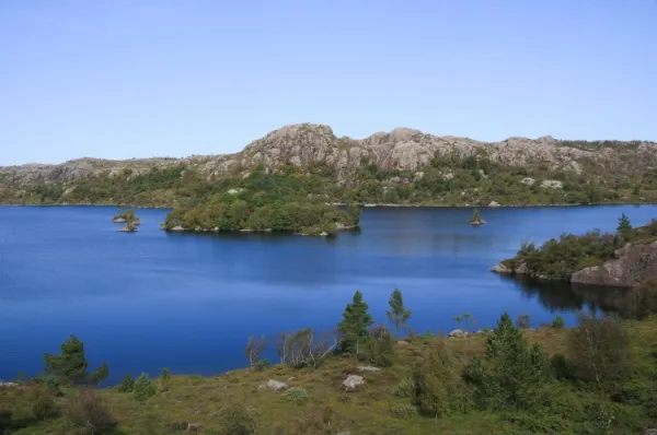 Anorthosite Felsformationen Ein klarer blauer See mit anorthositen Felsformationen im Hintergrund.