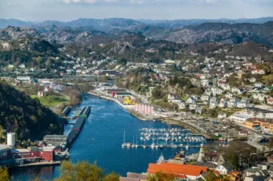 Blick auf die Bucht von Egersund mit der Stadt und dem Hafen, im Hintergrund ein Bergpanorama.