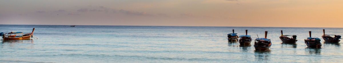 Fischerboote auf dem Wasser bei Sonnenuntergang in Koh Chen.