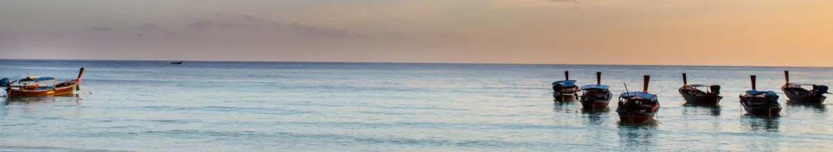 Fischerboote auf dem Wasser bei Sonnenuntergang in Koh Chen.