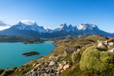 Spitze Bergkette mit See und Wiesenlandschaft im Vordergrund in der Nähe von Puerto Natales.