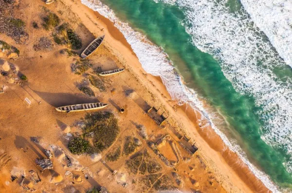 Luftbild mehrerer Holzboote an der Küste von Lomé.