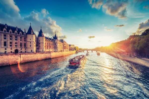 Flusskreuzfahrt auf der Seine in Paris bei Sonnenuntergang Entspannte Flusskreuzfahrt vorbei an historischen Sehenswürdigkeiten in Paris, Fokus auf Destination und Landschaft.