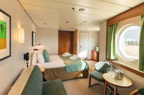 Expedition Suite MS Midnatsol Die Expedition Suite auf der MS Midnatsol mit einem großen Bullauge und einer gepflegten Kabinenausstattung.