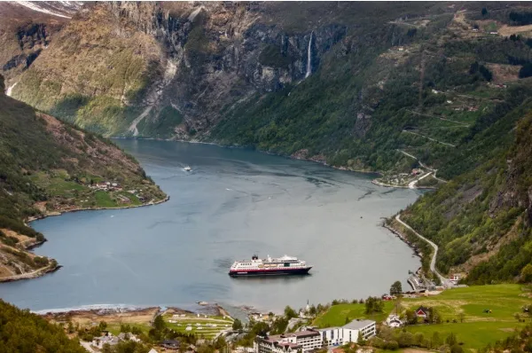 Die MS Midnatsol in Norwegen Die MS Midnatsol von Hurtigruten liegt in einer norwegischen Bucht umgeben von Bergen.