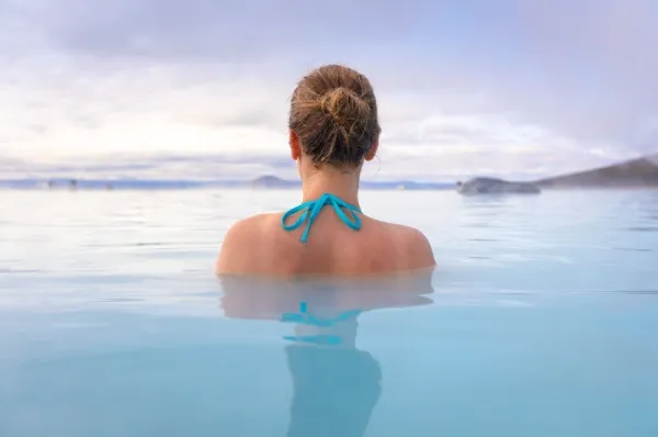Eine Frau badet in einem natürlichen Pool - ganz alleine. Regent Seven Seas erfüllt Ihnen auf Ihrer Reise alle Wünsche.