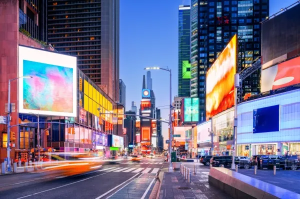 Ihr Hotel liegt ganz in der Nähe des berühmten Times Square Times Square in New York mit bunten Werbetafeln am Abend.