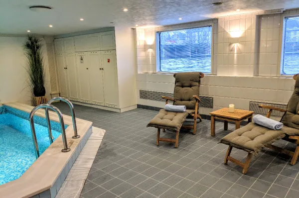 Wellnessbereich mit Indoor-Pool auf der MS VistaClassica Der Wellnessbereich der MS VistaClassica mit dem beheizten Indoor-Pool, einer Einstiegsleiter und zwei Ruheliegen aus Holz, die mit Blick auf den Fluss zum Entspannen einladen.