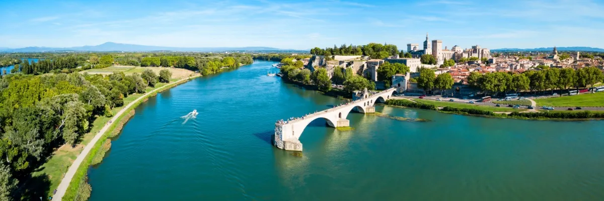 Bereisen Sie die schönsten Flüsse Frankreichs Avignon an der Rhône. Im Vordergrund ist die berühmte Pont St. Bénézet zu sehen, die im Fluss endet.