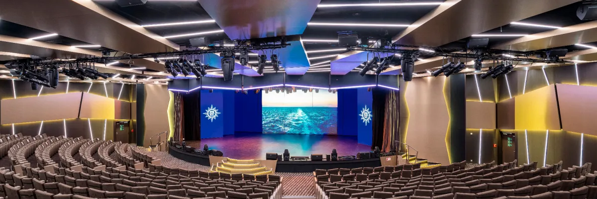 Das moderne und geräumige Le Grand Théâtre auf der MSC Virtuosa, mit Reihen von bequemen Sitzen, einer großen Bühne mit LED-Bildschirmen, die eine Meereslandschaft zeigen, und einer komplexen Beleuchtungsanlage.