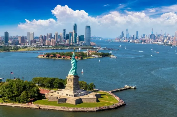 Panoramasicht auf die Skyline von New York und im Vordergrund die Freiheitsstatue.