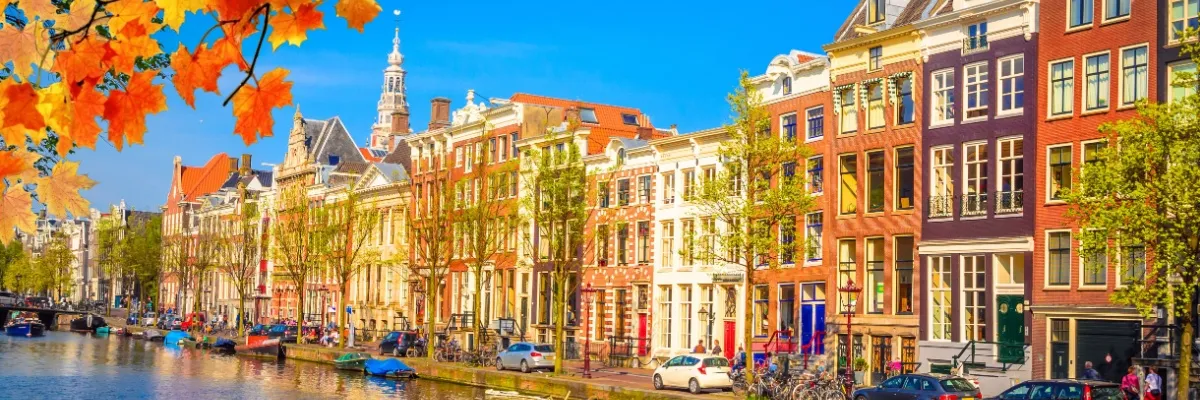 Herbstliche Farbenpracht in den Grachten Amsterdams mit Herbstlaub und bunten Häusern.