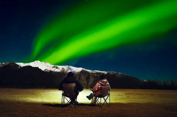 Mit Campingstühlen Polarlichter anschauen: Reisen Sie mit einem Kreuzfahrtschiff und erleben Sie atemberaubende Polarlichter.