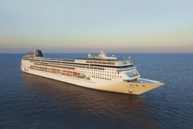 Die MSC Sinfonia auf hoher See bei untergehender Sonne.