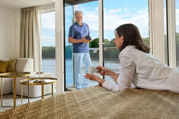 Entspannt Reisen mit AMADEUS Ein Paar trinken Kaffee auf ihrer luxuriösen Kabine auf einem AMADEUS Schiff.