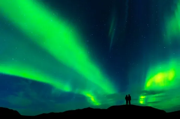 Silhouette eines Paares unter den Nordlichtern in Norwegen.