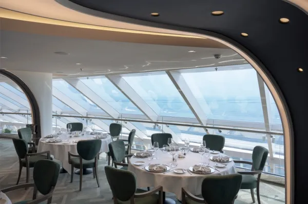 Restaurant mit runden Tischen an Bord eines MSC Schiffes.