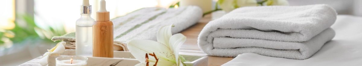 Ein zusammengefaltetes Handtuch und Massageöle.