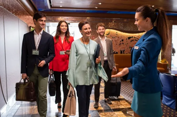 Costa C|Club Mehrere Personen werden von einer Costa-Mitarbeiterin an Bord in Empfang genommen.