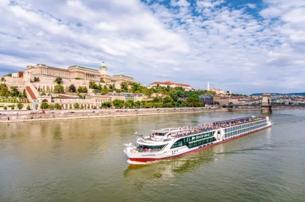 Die nickoVISION, stellvertretend für die Flotte von nicko cruises, auf der Donau. Am Ufer liegt die Burgpalastanlage in Budapest.