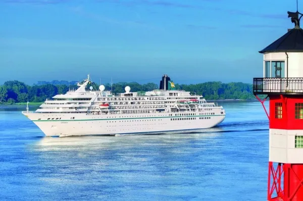 Die MS Amadea auf dem Wasser, im Vordergrund sieht man einen rot-weißen Leuchtturm.