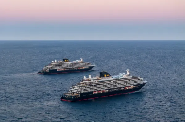 Die EXPLORA I & EXPLORA II auf hoher See. Sie fahren parallel zueinander über das Wasser. Der Himmel hat sich durch den Sonnenuntergang verfärbt.