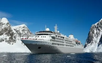 Silversea Silver Wind Kreuzfahrtschiff, Außenansicht vor der Antarktischen Halbinsel, mit Eisbergen, Gletschern und Bergen bei Tageslicht.