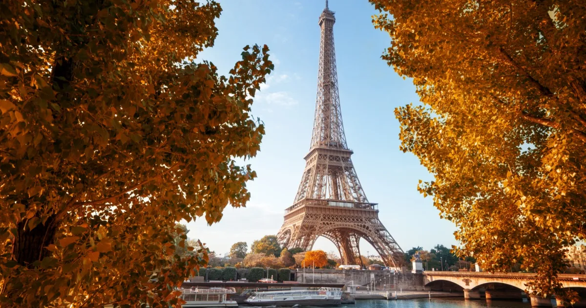 Der Pariser Eiffelturm zwischen herbstlichen Bäumen.