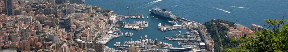 Die EXPLORA I im Port Hercule in Monaco. Der Hafen ist gefüllt mit kleineren Boots und die das Explora-Schiff sticht durch seine Größe sehr hervor.