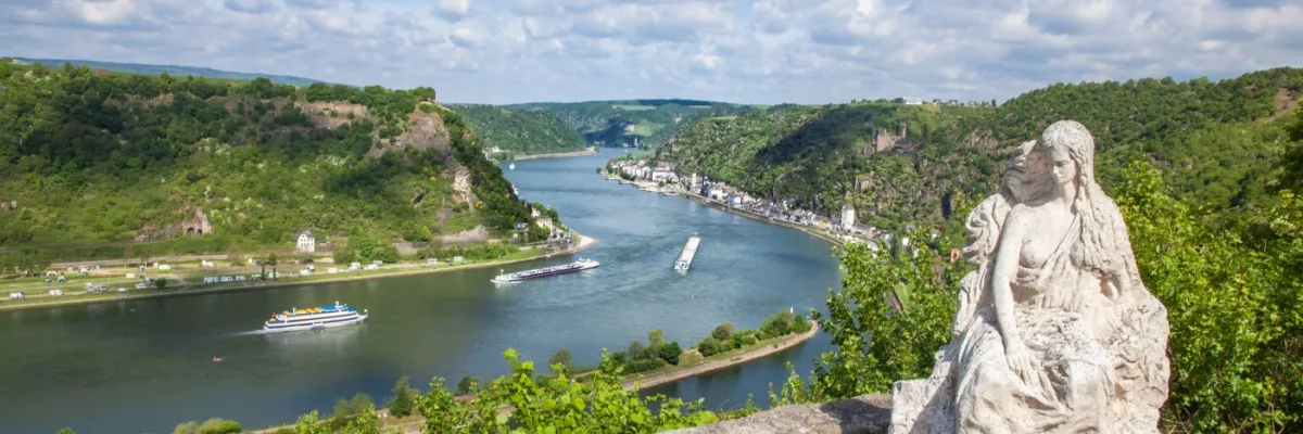 Rheinkreuzfahrten zum Black Friday: Mit A-ROSA zur Rhein-Romantik Loreley-Statue über dem Rhein. Im Hintergrund die Häuser von Sankt Goarshausen und Burg Katz.