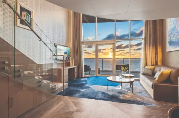 Kabinen auf der Legend of the Seas Ein Suitenbeispiel an Bord der Legend of the Seas mit Panoramablick auf das Meer, Wohnbereich und Treppe.