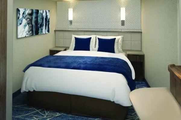 Innenkabine an Bord der Norwegian Encore mit Doppelbett und weiß-blauer Bettwäsche.