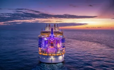 In einer beeindruckenden Perspektive steuert das Royal Carribean Schiff frontal dem leuchtenden Horizont entgegen, während die tiefstehende Sonne die gesamte Front in goldenes Licht taucht.