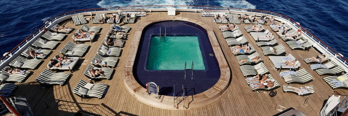 Das Ocean Bar & Pool auf Deck 10 mit einem Pool und Sonnenliegen am Heck des Schiffes.