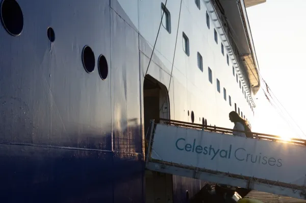 Der Aufgang zur Celestyal Discovery im Sonnenuntergang. Eine Frau bordet gerade.