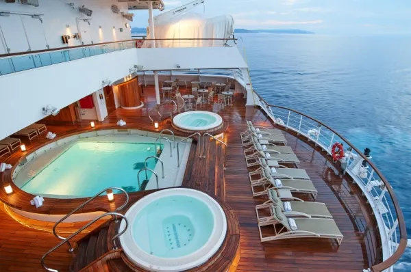 Ein Pool und zwei Whirlpools am Heck der Seabourn Encore. Das Schiff fährt durch einen kalten Ozean.