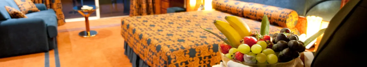 Der exklusive Service des MSC Yacht Clubs Ausschnitt aus einer Suite mit einem Butler der einen Obstkorb bringt, mit weißen klassisch, weißen Handschuhen.