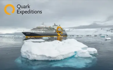 Das Schiff Ultramarine im Antarktischen Meer umgeben von Eisschollen. Das Logo der Reederei ist in der oberen, linken Ecke.