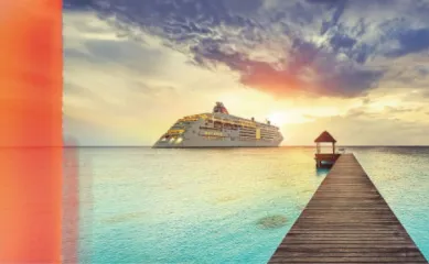 Ein Schiff von Hapag-Lloyd, welches sich von einem Holzsteg entfernt und in den Sonnenuntergang fährt.