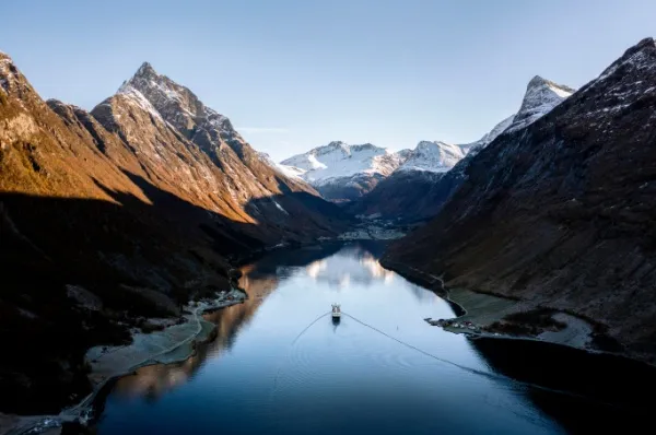 Ein Schiff der Havila Voyages Flotte durchquert den Hjørundfjord in Norwegen im Winter.