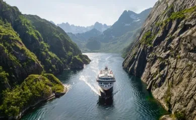 Havila Voyages Die Havila Castor von Havila Voyages in einem norwegischen Fjord. Jetzt bis zu 600 € sparen.